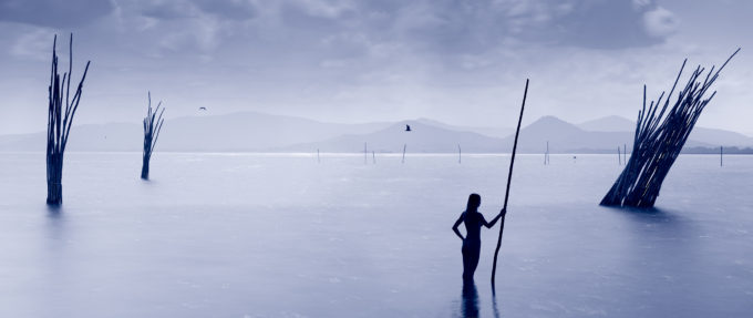 woman with pole in lake