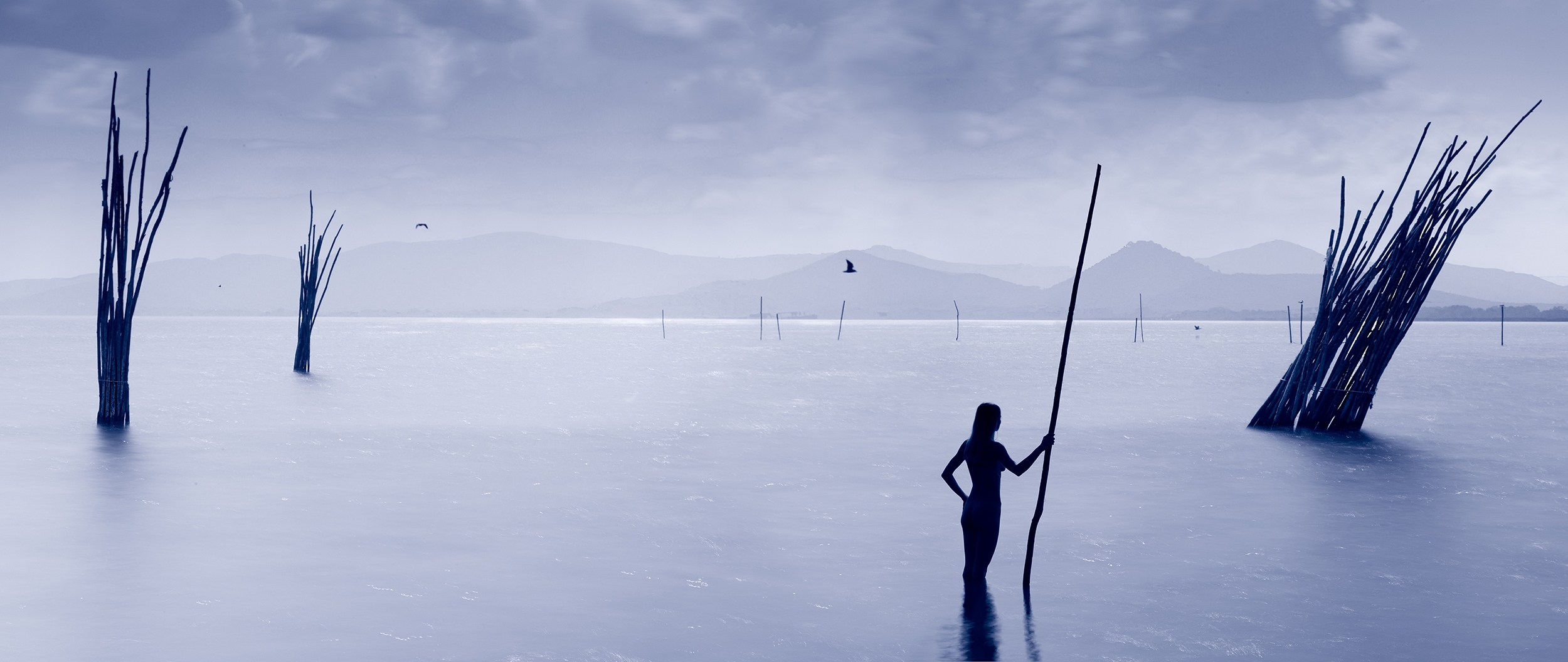 Water portrait- woman with pole, a water statue in lake Trasimeno
