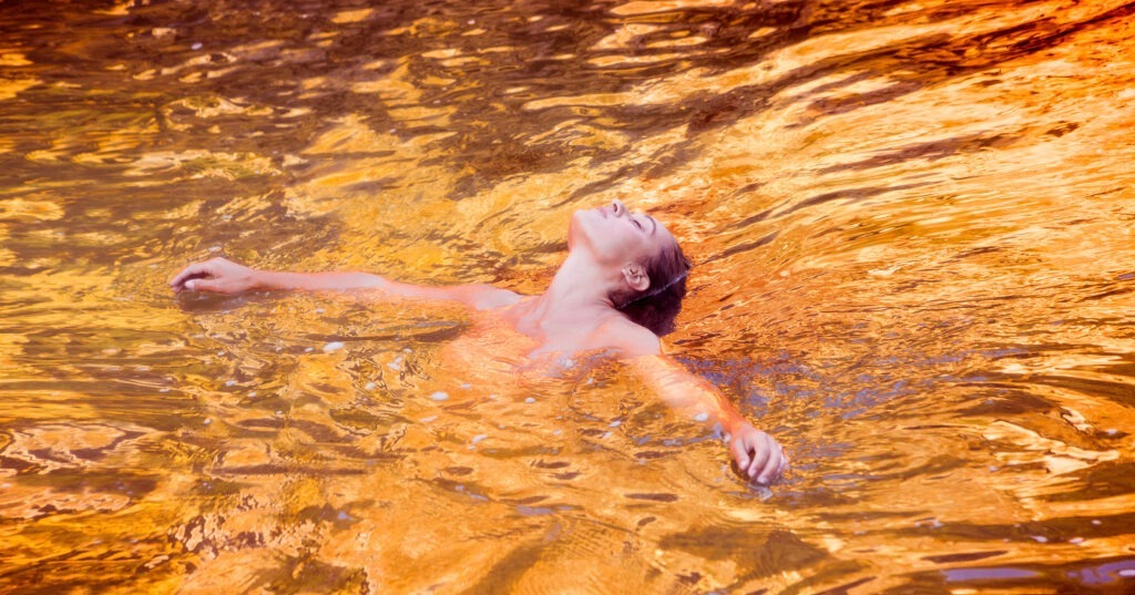 naked woman in golden pool
