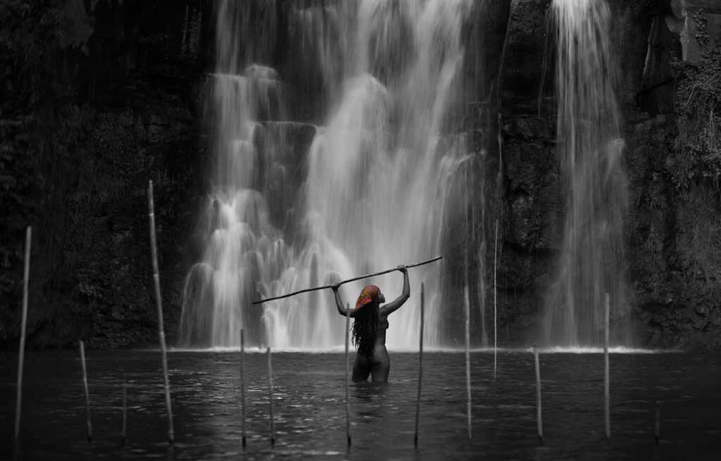 Minnehaha stands under the waterfall